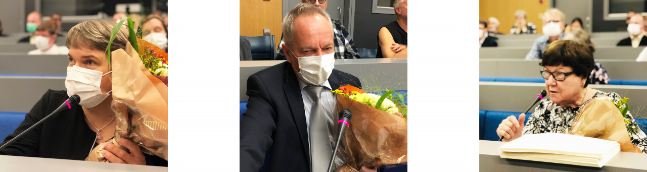 Kolme kuvaa. Ensimmäisessä nainen, jolla musta paita, kaulakoru ja lyhyet vaaleanrusket hiukset. Toisessa mies tumma pikkutakki päällä. Kolmannessa nainen, jolla mustavalkoinen paita, lyhyet tummanruskeat hiukset ja tummasankaiset silmälasit. Kaikki istuvat auditoriossa ja kaikilla on kukat kädesssä ja maski kasvoilla.