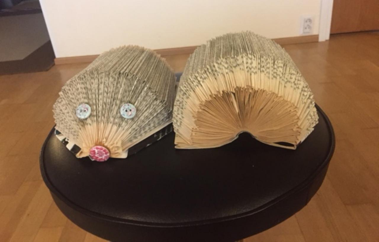 Kirjansivuista taitellut kirjasiilit, joihin on lisätty napit silmiksi ja nenäksi. Kuvassa siilit edestä ja takaa kuvattuna