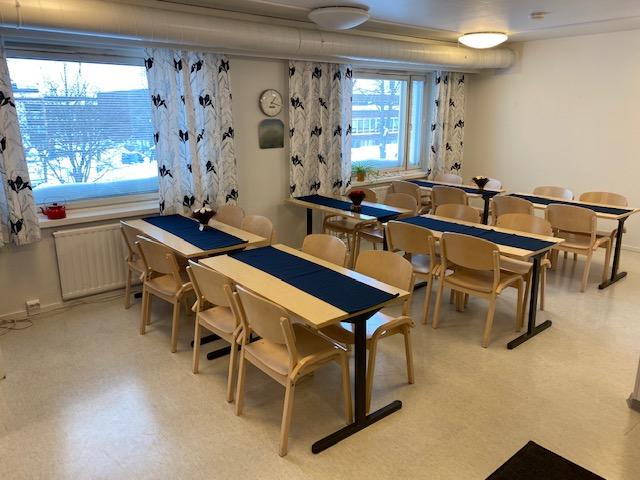 Kerhotilassa pöytiä ja tuoleja.