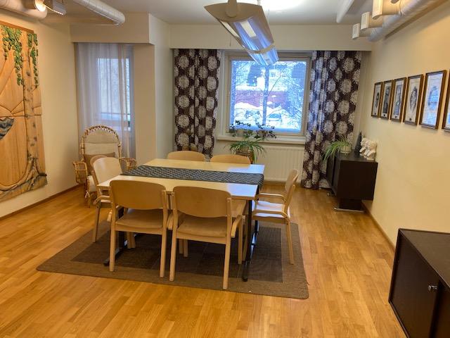 Huoneessa pöytä ja tuoleja.