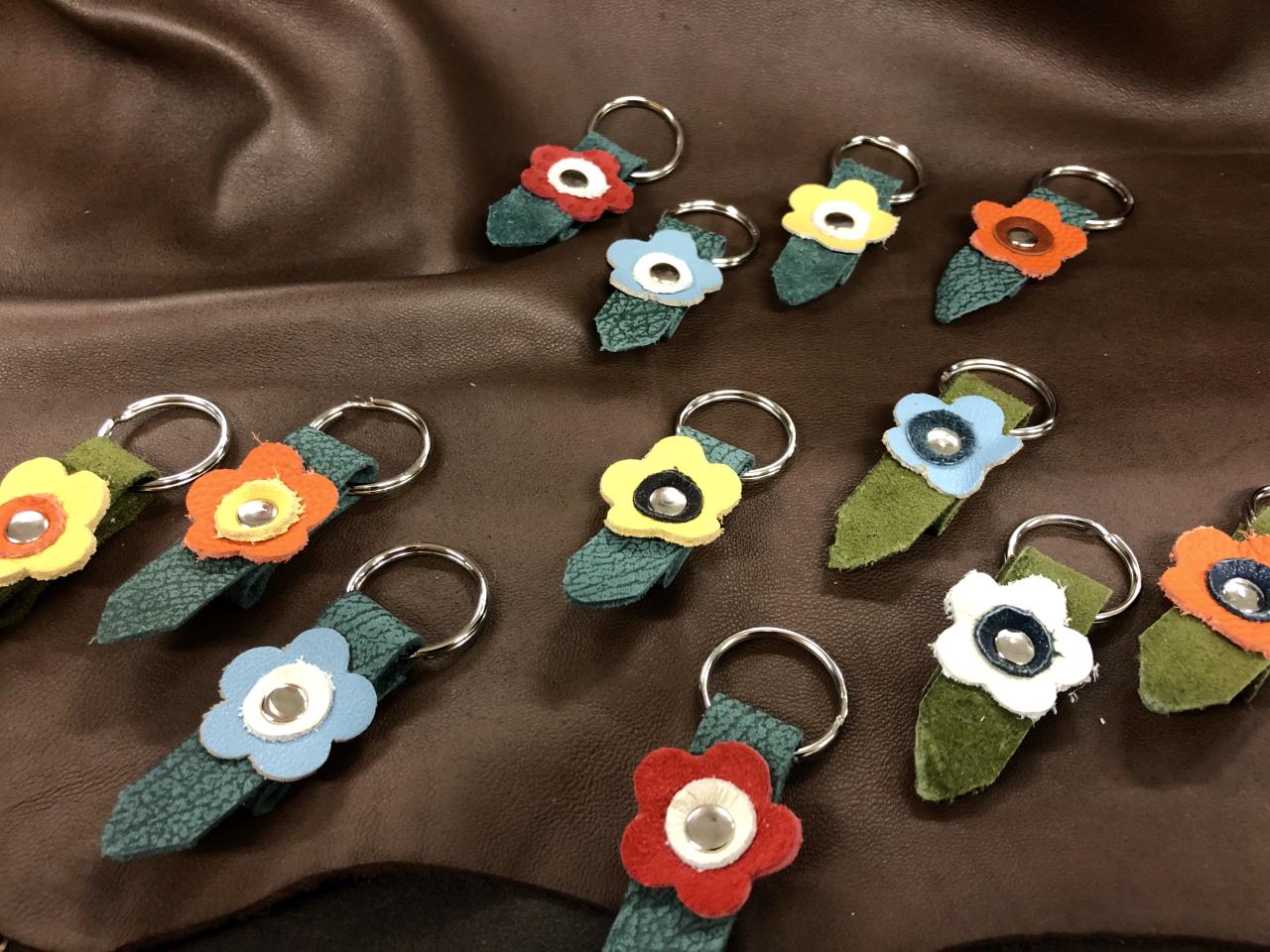 Erivärisistä nahoista tehtyjä kukan muotoisia avaimenperiä.