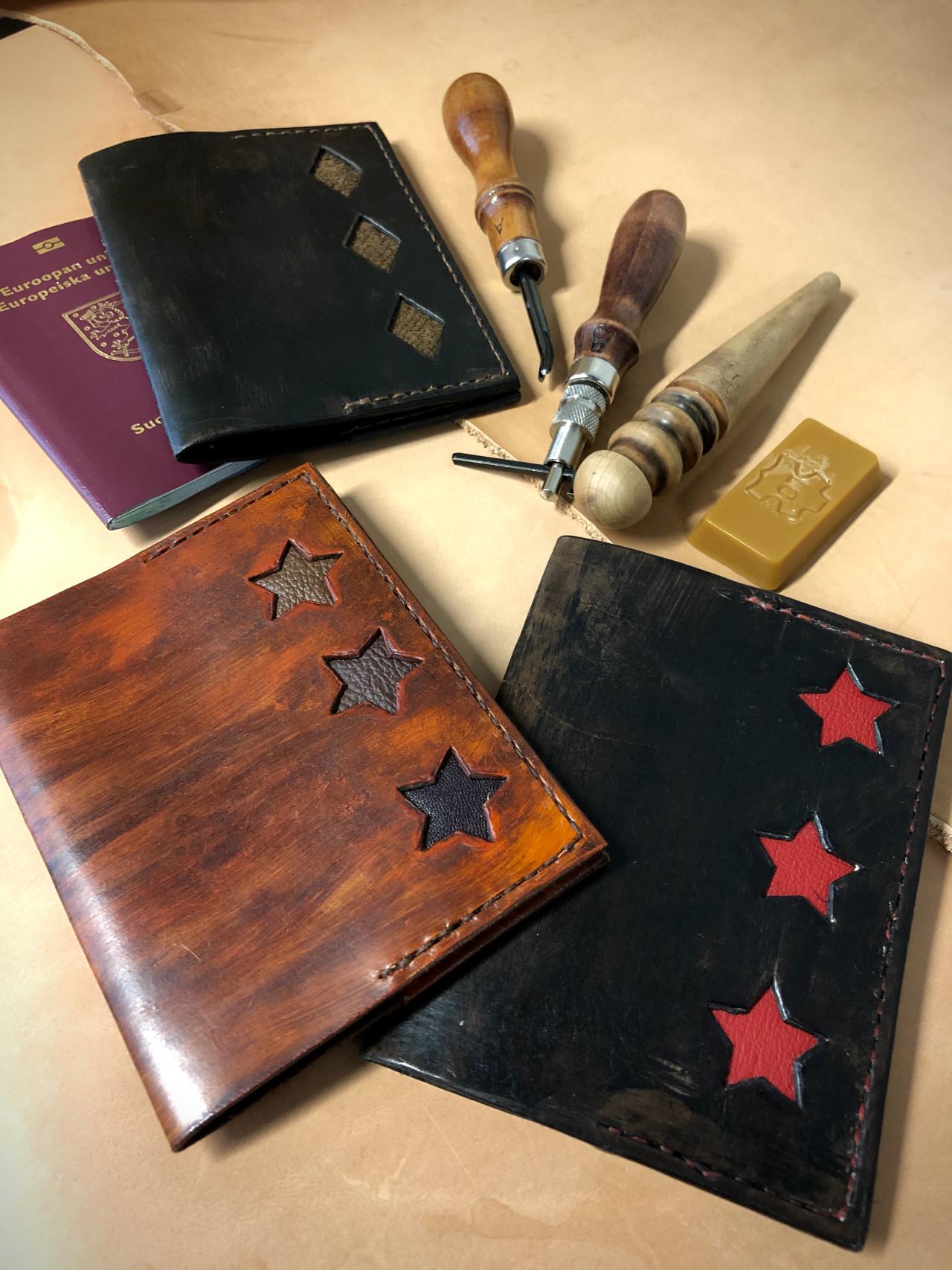 Nahasta valmistettuja passikoteloita, joissa intarsiatekniikalla tehtyjä tähti- ja salmiakkikuvioita. Taustalla nahkatyökaluja.