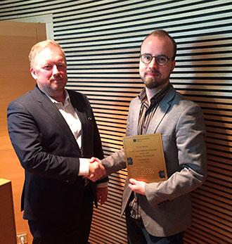 Kuvassa Näkövammaisten liiton toimitusjohtaja Jukka Tahvanainen ojentaa saavutettavuusteko-tunnustuksen Junat.net-sovelluksen kehittäjälle Joonas Rouhiaiselle.
