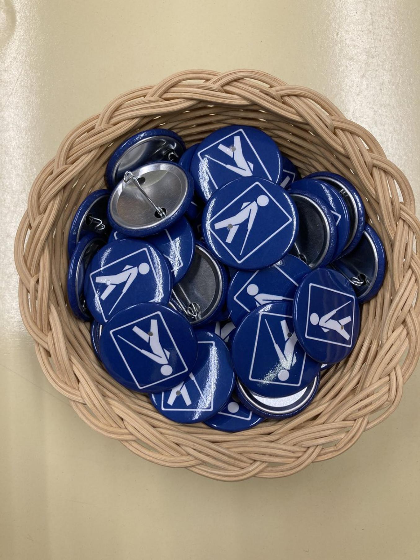 Näkövammais rintapinssit korissa